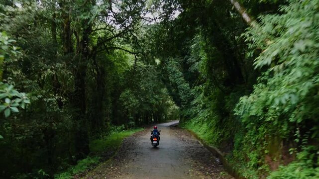 A person travelling solo on a scooter in greenery or nature in Kathmandu Nepal.