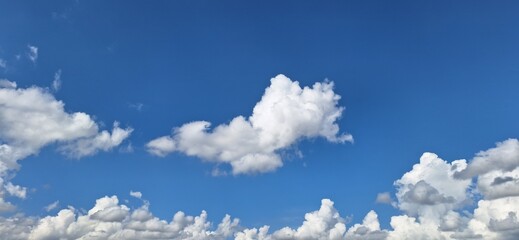 Beautiful blue sky with fluffy white clouds and copy space for background