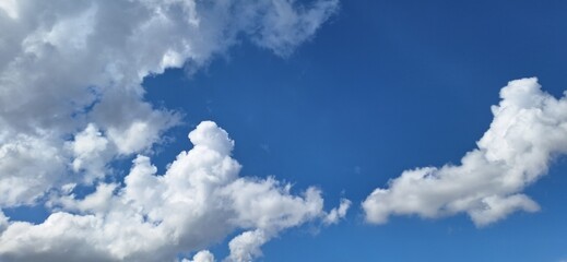 Beautiful blue sky with fluffy white clouds and copy space for background