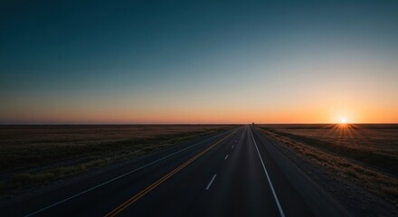 Empty highway stretches into a vibrant sunrise over a vast plain