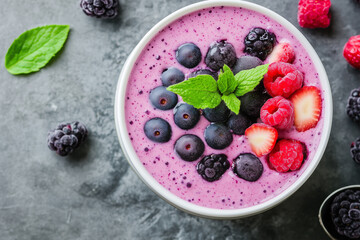Colorful fruit smoothie bowl with fresh berries and mint garnish