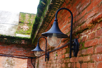 Street lights on walls. Vintage street lights. Street lights attached to old brick walls, retro-style lanterns.
