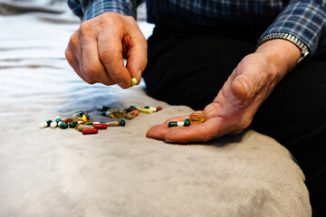 Man preparing medication on a soft surface at home during the afternoon