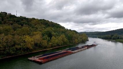 Barges of coal transported up river heading towards coal-fired electric power plant in Pennsylvania