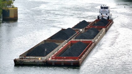 Barges of coal transported up river heading towards coal-fired electric power plant in Pennsylvania