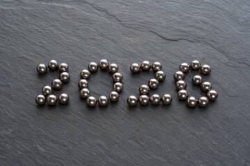 The Year Represented by Polished Hematite Spheres Arranged on a Dark Slate Surface