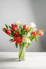 Spring floral background. Red tulips and Fresia white flower bouquet. Copy space