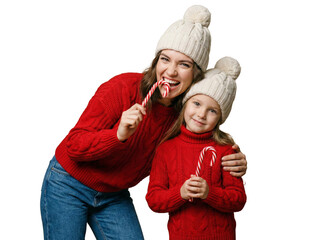 Happy mother and daughter in red sweaters and winter hats holding candy canes, festive Christmas family holiday concept on white background