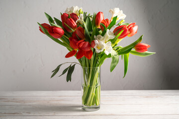 Spring floral background. Red tulips and Fresia white flower bouquet.