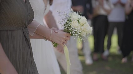 Rear view of parents gently escorting their bride daughter to the wedding ceremony. Emotional and symbolic moment of family support, love and transition, captured outdoors.