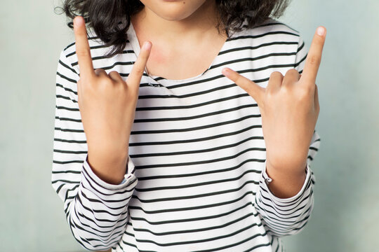 teenger with Sign of the Horns Hand Pose on White Background