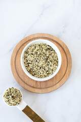 Organic hemp seeds on white kitchen table. Top view. Copy space.