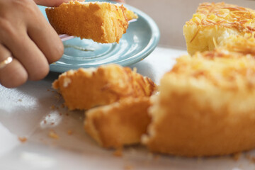 mom pickup a Golden Cake Texture with Crispy Cheese Topping