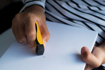 close up of someone erasing scribbles in a sketchbook