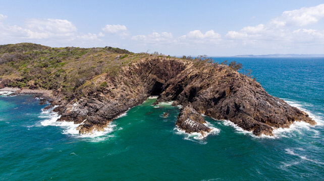 Aerial view of the rugged cliffs of Hell's Gates meet the turquoise sea, waves crashing against the rocks, a symphony of nature's power and beauty, Noosa Heads, Queensland, Australia.