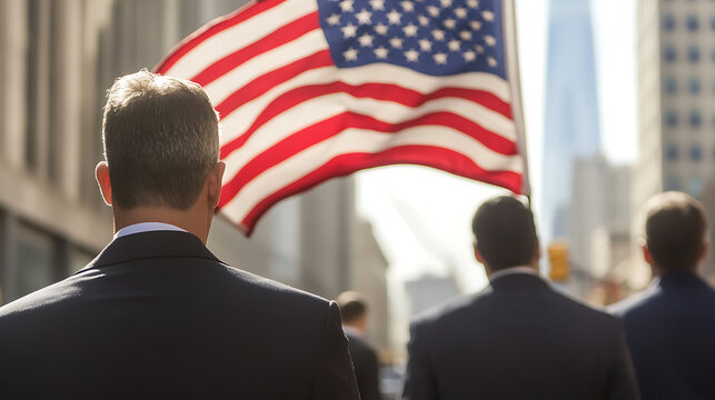 A group of men in suits walking down a city street with an American flag waving in the background. The image evokes themes of patriotism and corporate presence in the urban landscape. - Powered by Adobe