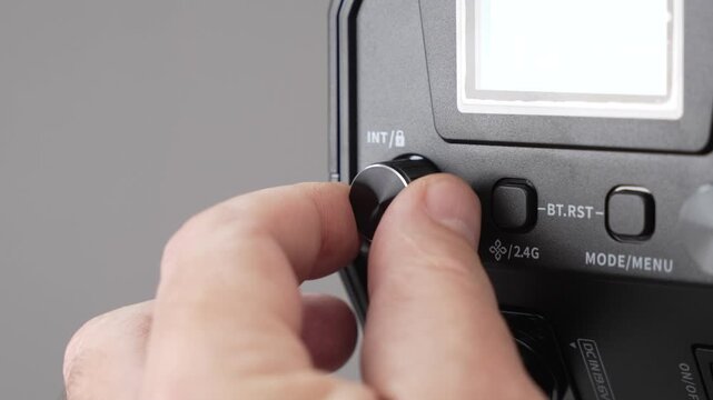 A studio LED light is adjusted while illuminating a white background. The clip shows precise control over brightness and color output.