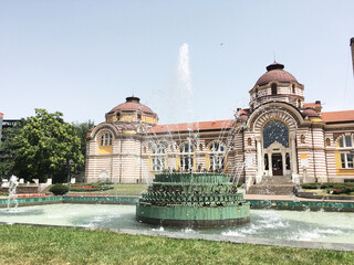 Beautiful architectural landmark in the center of Sofia, the capital of Bulgaria. Front yard with sprinkling fountain in front of palace. Sightseeing in European cities. Cultural heritage admiration.