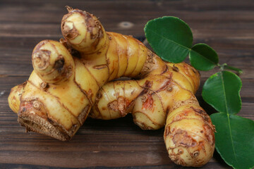 Fresh galangal roots on wooden background