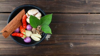 top view of various cooking spices such as chili, onion, garlic, cinnamon, pepper in a bowl