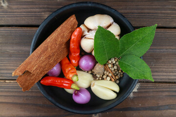 top view of various cooking spices such as chili, onion, garlic, cinnamon, pepper in a bowl