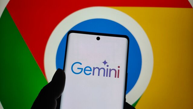 Smartphone displaying google gemini ai application logo held in front of the colorful google chrome browser icon background  , New York City, 15 December 2025
