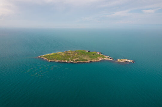 Aerial view of St. Ivan Island, a jewel of green vegetation amidst the vast, tranquil blue sea, a natural oasis of serenity, St. Ivan Island, Sozopol, Bulgaria.