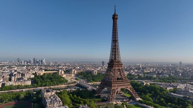 Aerial drone view of the streets of Paris, France, overlooking the famous Eiffel Tower and Champ de Mars at sunrise. Wide panorama of central Paris. Cinematic 4k. Europe from above.