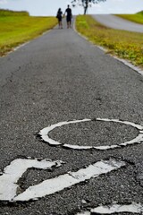 Close-up of Road Markings with a Couple Walking in the Distance