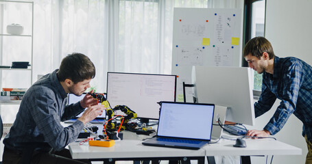 Team of male developers work code control robotics system and software automation project write prompt AI data bot at office. Artificial intelligence, collaboration, robotic, debugging, machine learn.