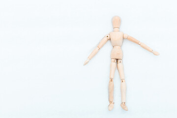 The wooden mannequin is in the snow