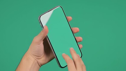 Close-up of hands interacting with a smartphone with a green screen on a teal background - Powered by Adobe