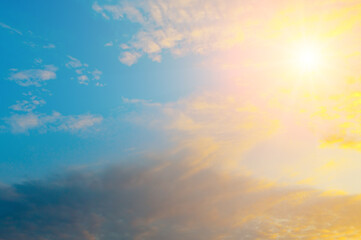 Golden Morning Sun Shining Through Blue Sky and Soft Clouds