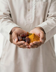 Middle Eastern man holding dates and yellow spices, isolated on white background