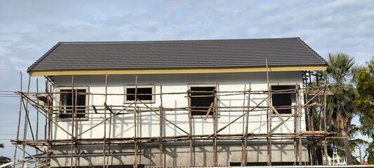 The house is still under construction with wooden scaffolding around it.