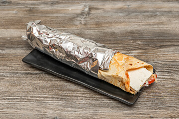 Beef shawarma with yogurt and herb sauce, served in pita bread with lettuce, tomato, onion, and hot...