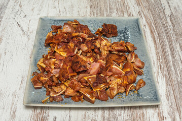 The art of achieving the perfect texture on the griddle: these pig's ears show off their shiny surface, crispy on the outside and tender on the inside, with a touch of coarse salt