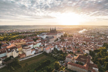 Glowing sunlight casts a warm hue over Prague Castle as it rises above the historic city. The...