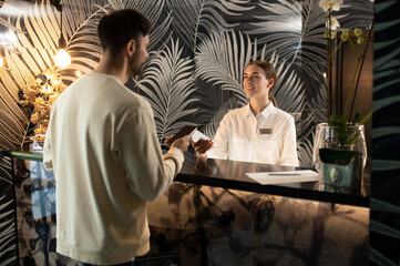 Receptionist talking to a male customer and arranging accommodation for him