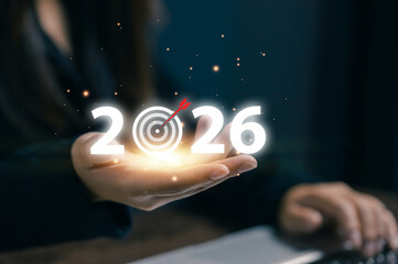 A professional holds a glowing 2026 target icon, representing business goals, future planning, strategic objectives, performance targets, and long-term success in modern enterprises.
