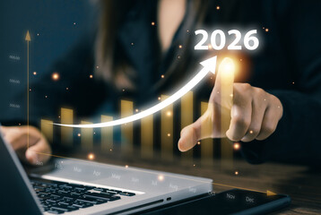 A business professional points to an upward arrow chart labeled 2026, representing financial growth, revenue increase, forecasting, investment success, and positive market trends.