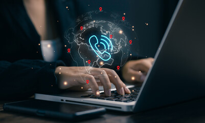 A professional types on a laptop with a global phone network hologram, representing VoIP communication, international call centers, customer service, telecom, and worldwide business connectivity.
