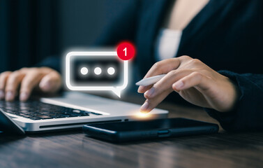 A professional uses a smartphone and laptop with a new message notification icon, representing instant messaging, digital communication, online interaction, and modern business connectivity.