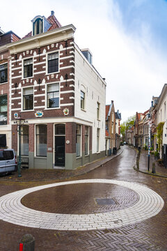 View of a quaint street corner with historic buildings and a circular design on the cobblestone ground, Haarlem, North Holland, Netherlands.