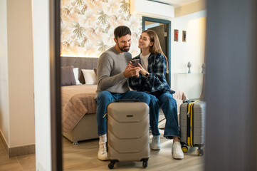 Couple sitting on the bed in a hotel room after arrival