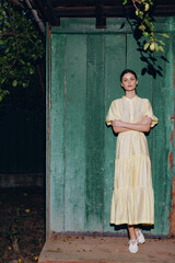 Obraz premium woman portrait in yellow vintage dress standing against green wall authenticity inclusivity