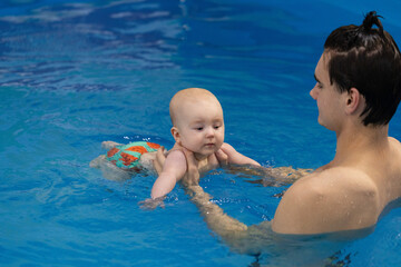 First experiences with water. Swimming lessons for newborn.