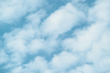 Light blue sky with soft fluffy white clouds, calm and peaceful nature background for design, weather, freedom and abstract concepts
