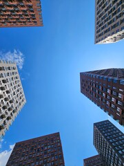 Group of buildings with a blue sky in the background. The buildings are tall and brown