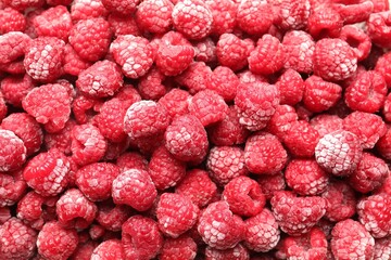 Frozen ripe raspberries as background, top view